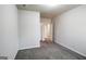 Bedroom featuring neutral gray walls, plush gray carpet, open doors, and bright, natural light at 7569 Bowhead Ct, Fairburn, GA 30213