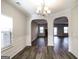 Dining room featuring modern chandelier, wood-look flooring, and an archway view into the living space at 7569 Bowhead Ct, Fairburn, GA 30213