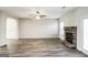 Open living room with a stone fireplace, ceiling fan, and wood-look flooring with a view of the entry archway at 7569 Bowhead Ct, Fairburn, GA 30213