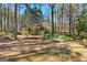 View of a private backyard surrounded by lush trees with a glimpse of the house in the background at 9491 Hidden Branch Dr, Jonesboro, GA 30236