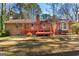 Backyard view showing a deck with access to the house and a brick chimney at 9491 Hidden Branch Dr, Jonesboro, GA 30236