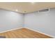 Finished basement area with wood floors, inset ceiling light and access to mechanicals at 9491 Hidden Branch Dr, Jonesboro, GA 30236
