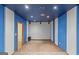 Finished basement with blue accent wall, carpeted floors and door to storage at 9491 Hidden Branch Dr, Jonesboro, GA 30236
