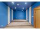 Finished basement rec room with elevated platforms, carpeted floors and painted blue ceiling and walls at 9491 Hidden Branch Dr, Jonesboro, GA 30236