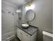 Stylish bathroom boasts a granite countertop, bowl sink, and elegant lighting and tiled shower at 9491 Hidden Branch Dr, Jonesboro, GA 30236