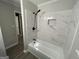 Modern bathroom features a bathtub with a stylish rainfall shower head and white marble tile at 9491 Hidden Branch Dr, Jonesboro, GA 30236