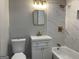 Elegant bathroom with a white vanity, framed mirror, tiled walls, and shower-tub combo at 9491 Hidden Branch Dr, Jonesboro, GA 30236
