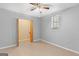 A cozy bedroom featuring neutral walls, tile floors, a ceiling fan, window and closet at 9491 Hidden Branch Dr, Jonesboro, GA 30236