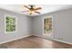 This comfortable bedroom includes light hardwood floors and two windows for natural light at 9491 Hidden Branch Dr, Jonesboro, GA 30236