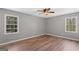 This comfortable bedroom includes light hardwood floors and two windows for natural light at 9491 Hidden Branch Dr, Jonesboro, GA 30236