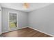 Neutral bedroom with a ceiling fan and light hardwood floors and a view to the yard at 9491 Hidden Branch Dr, Jonesboro, GA 30236