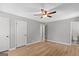 Spacious bedroom with light hardwood floors, ceiling fan, walk-in closet, and natural light at 9491 Hidden Branch Dr, Jonesboro, GA 30236