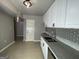 Bright kitchen with white cabinets, stainless steel appliances, and a gray tile backsplash at 9491 Hidden Branch Dr, Jonesboro, GA 30236
