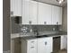 Well-lit kitchen featuring stainless steel appliances, white cabinets, and stylish gray backsplash at 9491 Hidden Branch Dr, Jonesboro, GA 30236