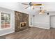 Living room with a stone fireplace, wood-look vinyl floors, and a window view at 9491 Hidden Branch Dr, Jonesboro, GA 30236