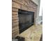 Close-up of a stone fireplace with a black metal screen and decorative accents at 946 Creek Run Pl, Temple, GA 30179
