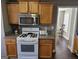 Bright kitchen featuring wood cabinets, granite countertops, and modern gas range at 946 Creek Run Pl, Temple, GA 30179