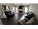Spacious living room with dark floors, a brick fireplace, and comfortable leather seating at 946 Creek Run Pl, Temple, GA 30179