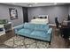 Living room with a blue sofa, rug, desk, and a bed in the background at 946 Creek Run Pl, Temple, GA 30179