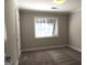 Comfortable bedroom featuring plush carpeting, a bright window, and neutral wall paint at 117 Rondak Se Cir, Smyrna, GA 30080