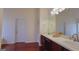 Bathroom with double sink vanity, large mirror, wooden cabinets, and tiled countertops at 7926 Palomino Pass, Riverdale, GA 30274