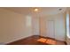 Sunlit bedroom featuring hardwood floors, neutral walls, and two doors at 7926 Palomino Pass, Riverdale, GA 30274