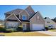 A beautiful two-story home boasting an attached garage, a well-maintained lawn, and a charming mailbox at 7926 Palomino Pass, Riverdale, GA 30274