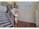Light-filled foyer featuring hardwood floors, decorative staircase with iron railings, and views into adjoining rooms at 7926 Palomino Pass, Riverdale, GA 30274