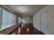 Bright and airy living room with hardwood floors, chandelier, and large windows for natural light at 7926 Palomino Pass, Riverdale, GA 30274