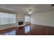 Spacious living room features hardwood floors, a ceiling fan, and a cozy fireplace at 7926 Palomino Pass, Riverdale, GA 30274