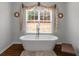 Bright bathroom featuring a modern freestanding tub under a large window at 1500 Highway 155 North, Mcdonough, GA 30252