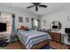 Cozy bedroom with wood floors, ceiling fan, and two windows with blue curtains at 1500 Highway 155 North, Mcdonough, GA 30252