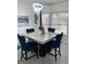 Dining area illuminated by stylish light fixtures and featuring a marble dining table with blue chairs at 7193 Cavender Sw Dr, South Fulton, GA 30331