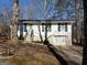 Charming single-story home featuring white siding, black shutters, and an attached garage nestled on a wooded lot at 1995 Tara Nw Ct, Kennesaw, GA 30144