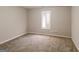 This bedroom features neutral walls, carpeted floors, and a bright window at 136 Leguin Forest Dr, Locust Grove, GA 30248