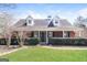 Charming brick home with dormer windows, lush landscaping, and inviting front entrance at 136 Leguin Forest Dr, Locust Grove, GA 30248