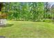 Spacious backyard featuring lush green grass and mature trees creating a serene, private outdoor space at 643 Old Greenville Rd, Fayetteville, GA 30215