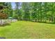Expansive backyard with manicured lawn bordered by mature trees and a white picket fence at 643 Old Greenville Rd, Fayetteville, GA 30215