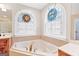 Bathroom features a soaking tub, tile floors, and custom windows at 643 Old Greenville Rd, Fayetteville, GA 30215