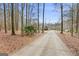 Long driveway leading to a secluded red brick home surrounded by trees at 643 Old Greenville Rd, Fayetteville, GA 30215