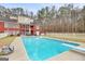 Backyard showcasing a spacious pool, patio, and a charming red brick home at 643 Old Greenville Rd, Fayetteville, GA 30215