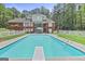 In-ground pool with diving board in private backyard with a brick house and trees at 643 Old Greenville Rd, Fayetteville, GA 30215