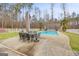 Backyard swimming pool with pristine light blue water and outdoor patio table and chairs at 643 Old Greenville Rd, Fayetteville, GA 30215