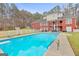 Expansive pool behind a red brick home with an open patio and manicured lawn at 643 Old Greenville Rd, Fayetteville, GA 30215