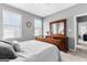 Bedroom with dresser, a bed with a white comforter, two windows, and neutral gray walls at 300 Tarragon Dr, Fayetteville, GA 30215