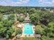 Aerial view of a community pool, tennis courts, mature trees, and a clubhouse at 300 Tarragon Dr, Fayetteville, GA 30215