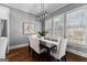 Inviting dining room with modern lighting fixture, large windows, and a dining table set for six at 300 Tarragon Dr, Fayetteville, GA 30215