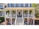 Inviting front porch featuring classic columns, gray door with wreath, and hanging plants at 300 Tarragon Dr, Fayetteville, GA 30215
