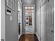 Hallway view leading to a laundry room, showcasing the unique tile flooring and a stacked washer and dryer at 300 Tarragon Dr, Fayetteville, GA 30215