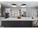 Close-up view of the kitchen island with white marble countertop, sleek lighting, and stainless steel appliances at 300 Tarragon Dr, Fayetteville, GA 30215